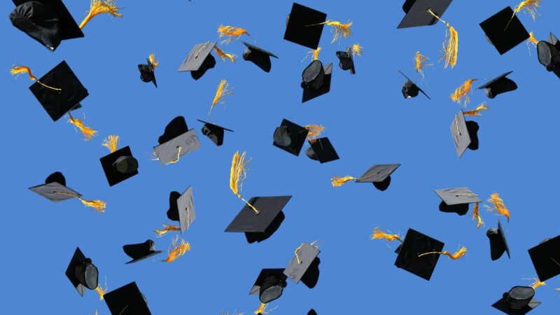Graduation caps thrown in air